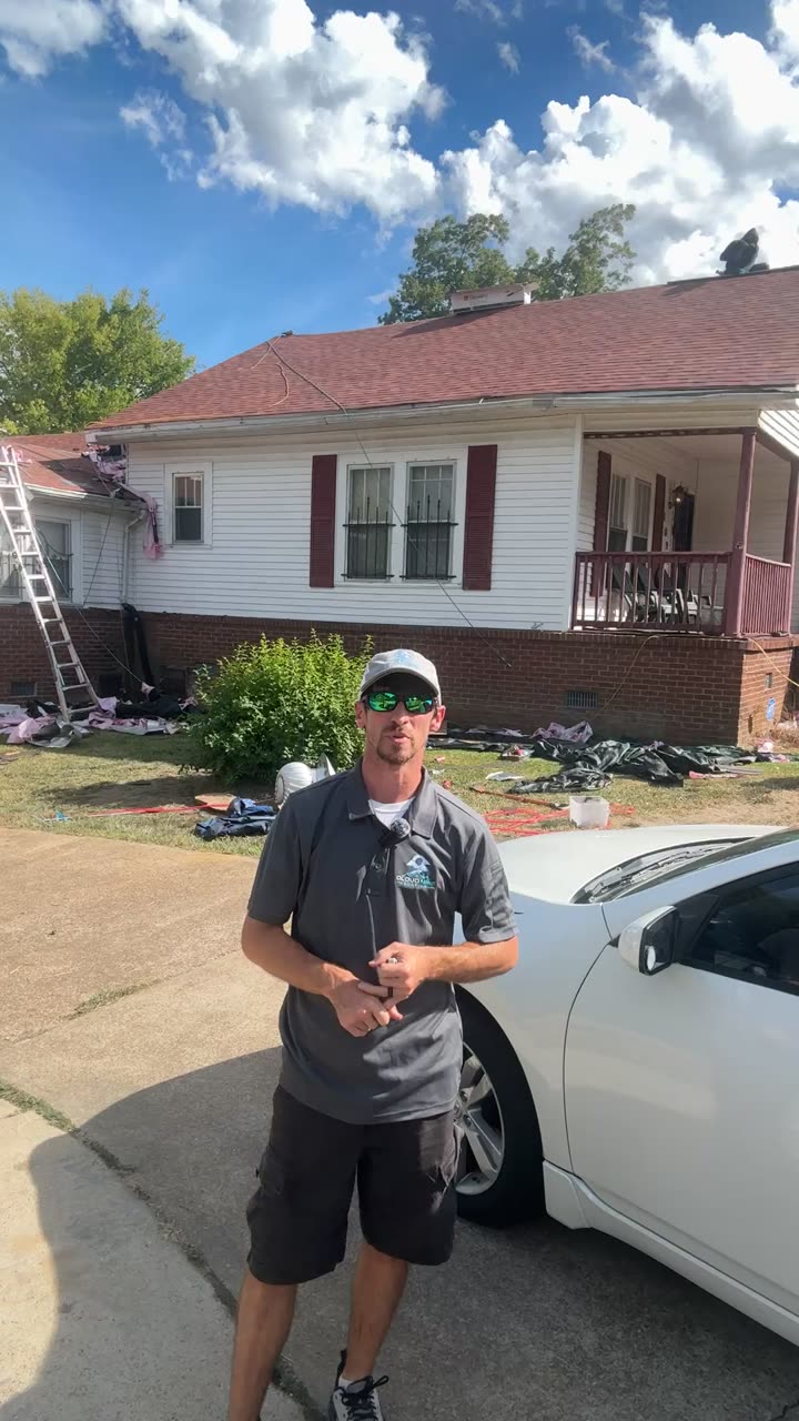 Robert Lollar on a job site in Oxford, a roof mid tear-off behind him